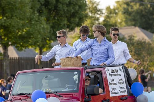 four juniors from homecoming court in open jeep